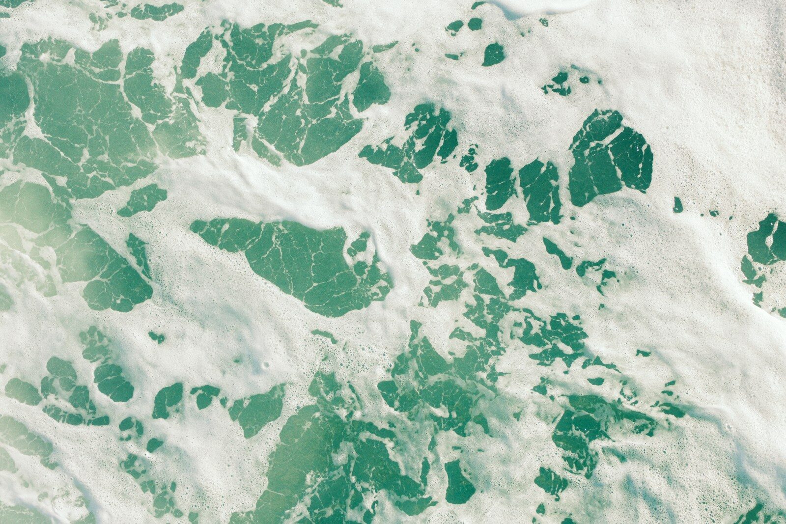 Turquoise water with white foam patterns